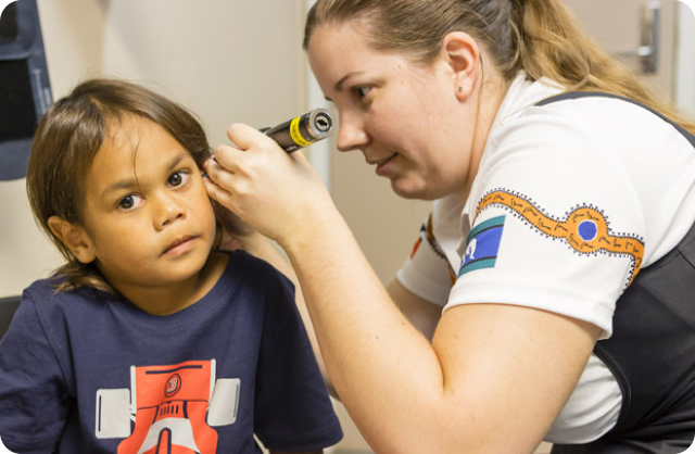 A child gets her ears checked by a doctor